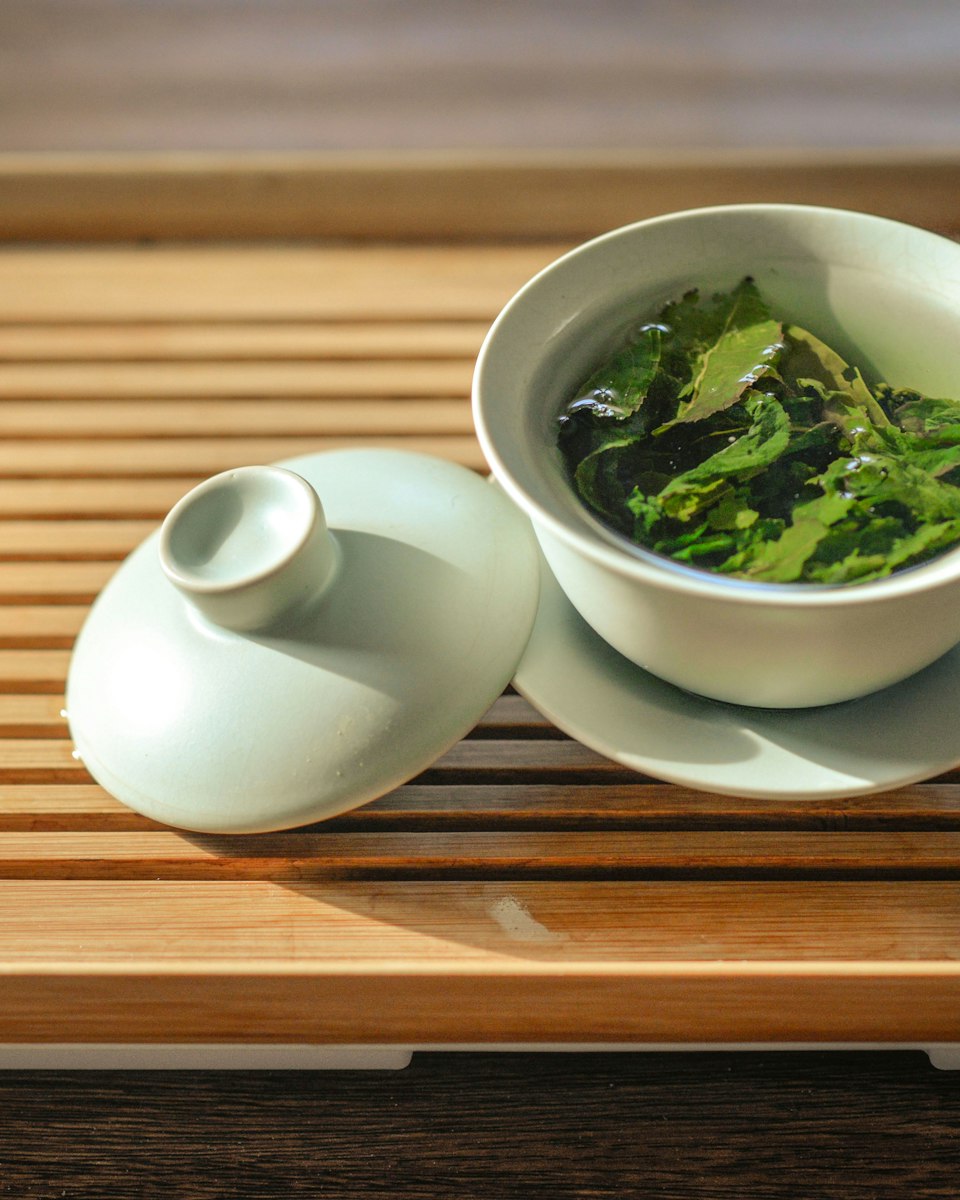 Unfurled gyokuro leaves in a pale celadon gaiwan